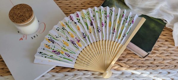 Éventail avec des fleurs vertes, violettes et jaunes